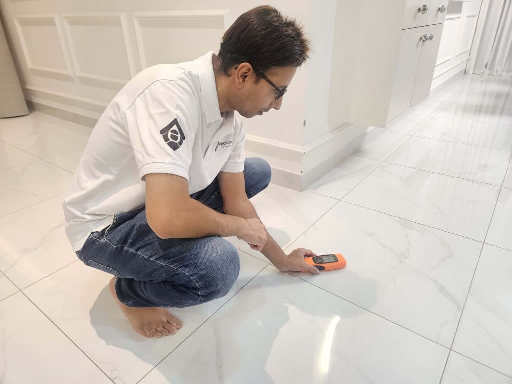 Inspector checking floor tile levels and grout